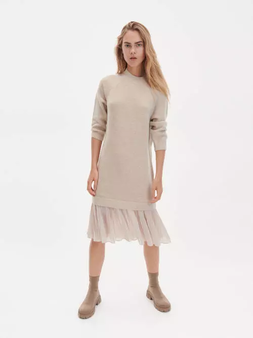 Moderné úpletové šaty v neutrálnej krémovej farbe s dlhými rukávmi a volánom